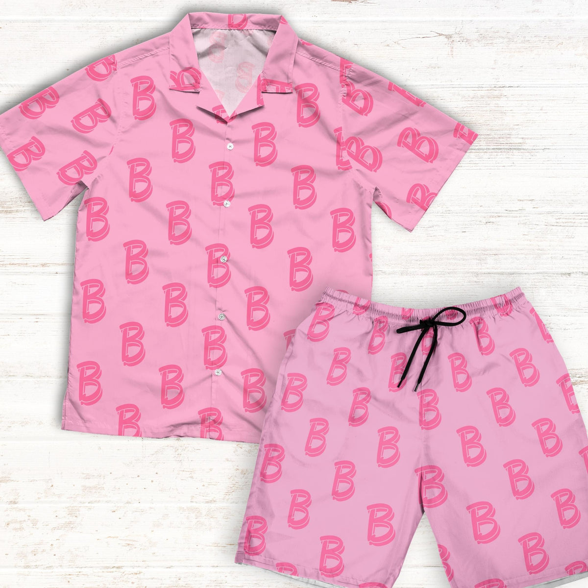A vibrant pink shirt featuring a repeated 'B' letter pattern, paired with matching shorts. The shirt has a relaxed fit with a Cuban collar and white buttons, while the shorts have an elastic waistband. The ensemble captures the essence of Ken's iconic look from the Barbie movie, making it an ideal choice for cosplay events.