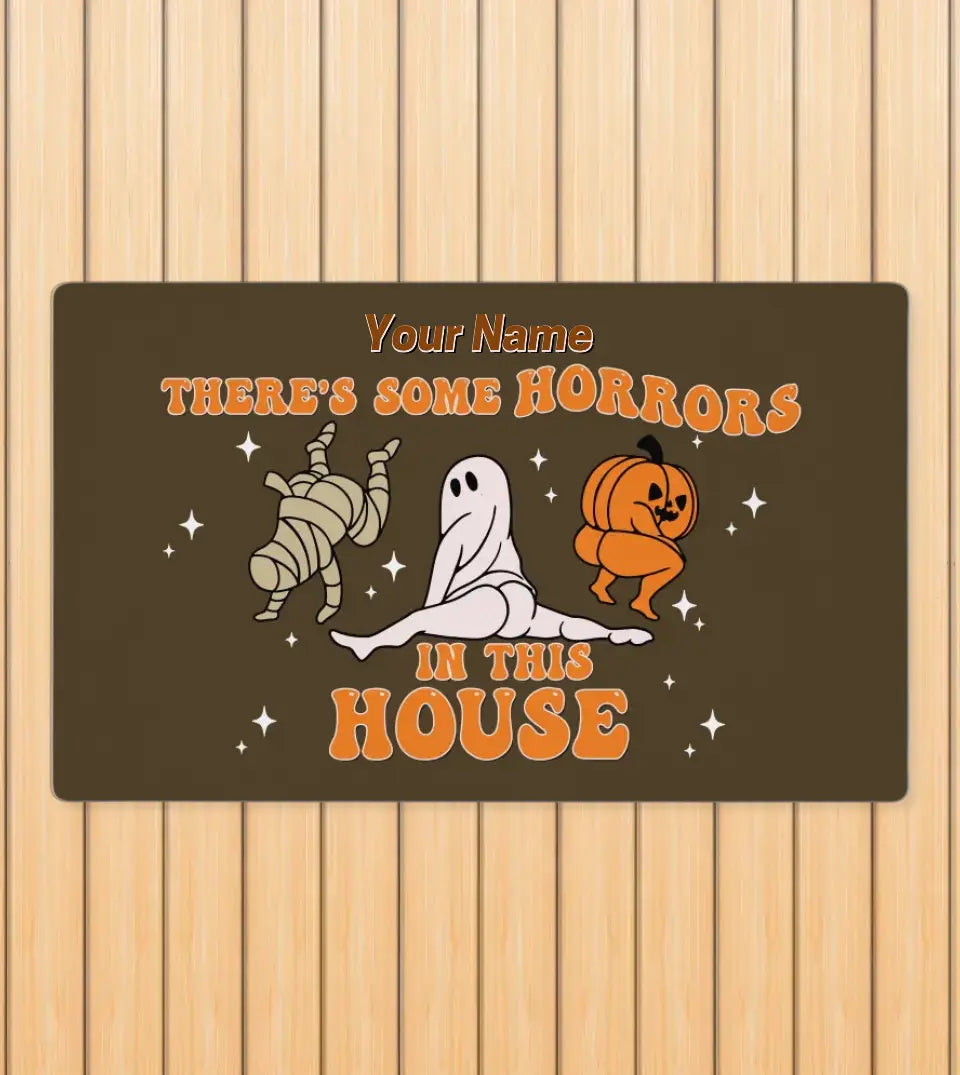 Customizable doormat featuring the humorous quote 'There's Some Horrors In This House', inspired by Cardi B's song, with space for a personalized name at the top.